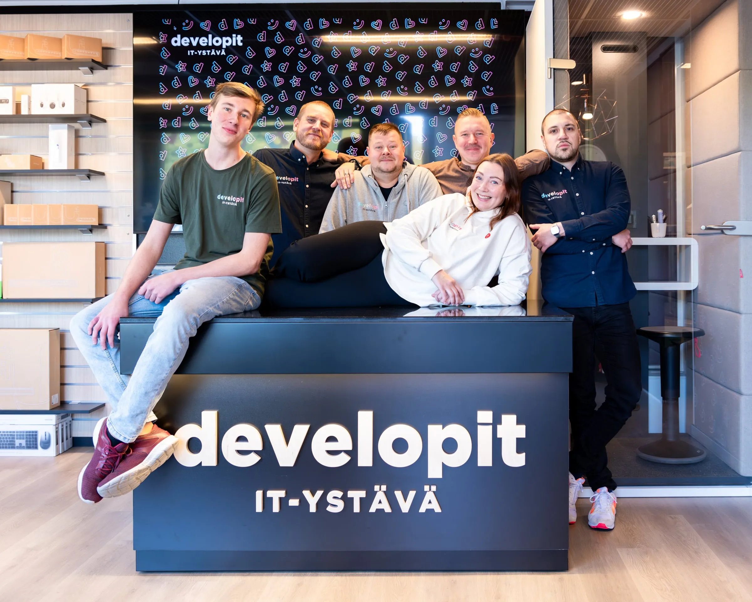 The Developit team gathered around the developit desk in the store.